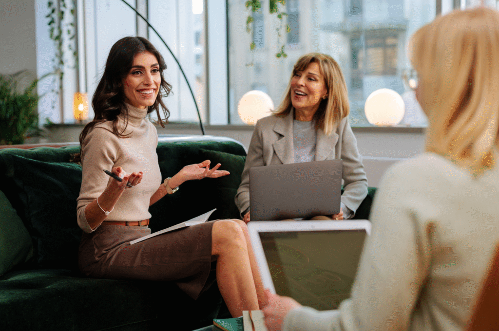 Tre personer diskuterar runt datorer