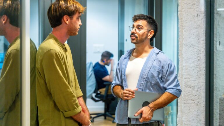 Två män som pratar i korridoren på kontoret